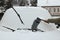 Woman cleaning car windshield from snow with brush outdoors, closeup