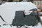 Woman cleaning car windshield from snow with squeegee outdoors, closeup