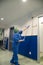 Woman cleaning the ceiling the walls of the pre-operating room with a special brush.