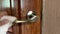 Woman cleaning door handle with antiseptic disinfectant wet wipe close up.