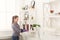 Woman cleaning dust from bookshelf