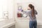 Woman cleaning dust from bookshelf