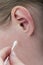 Woman cleaning ear with cotton swab