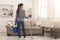 Woman with cleaning equipment ready to clean room