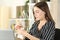 Woman cleaning eyeglasses with a tissue at home