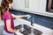 Woman cleaning faucet at kitchen sink