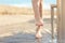 Woman cleaning feet in a shower after beach day