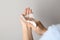 Woman cleaning hand with antiseptic wipe on grey background, closeup. Virus prevention