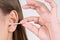 Woman cleaning her ear with a cotton swab. A woman suffered an infection after using the sticks incorrectly
