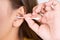 Woman cleaning her ear with a cotton swab. A woman suffered an infection after using the sticks incorrectly