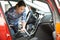 Woman Cleaning Interior Of Car Using Vacuum Cleaner