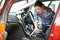 Woman Cleaning Interior Of Car Using Vacuum Cleaner