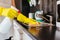 Woman cleaning kitchen cabinets with sponge and spray cleaner