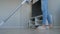 Woman cleaning living room with modern white upright vacuum cleaner