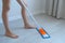Woman is cleaning and mopping the linoleum floor, legs close-up.