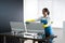 Woman Cleaning Office Desk And Computer Monitor