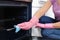 Woman cleaning oven rack with rag in kitchen