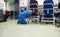 Woman from the cleaning service of a hospital crouching cleaning the wheels of a patient chair in the operating room beforehand.