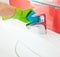 Woman cleaning sink and faucet