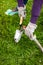 Woman cleaning small spade with water from hosepipe