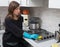 Woman cleaning stainless steel gas surface in the kitchen at ho