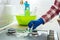 Woman cleaning stainless steel gas surface in the kitchen with rubber gloves