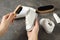 Woman cleaning stylish footwear on grey stone background, closeup. Shoe care accessories