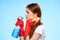 woman with cleaning supplies in the hands of professional service delivery blue background