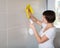 Woman cleaning tiled wall