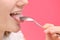 Woman Cleaning Tongue Using Spoon