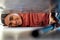 Woman cleaning under a bed in bedroom with vacuum for the floor to clean dust, dirt or bacteria. Happy, smile and