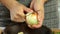 Woman cleaning white onion with big knife