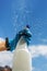 Woman cleaning a window using clean sprayer in action with blue gloves. Copy space, banner