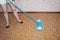 A woman cleans the floor with a MOP in a room covered with linoleum.