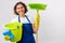 Woman cleans the house. The woman is holding a mop and a bucket and gloves and a cleaning sponge