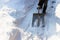 Woman cleans path from snow with metal shovel. Snow cleaning