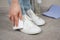 A woman cleans sneakers from dust and dirt with a melamine sponge