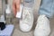 A woman cleans sneakers from dust and dirt with a melamine sponge