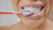 Woman cleans teeth with toothpaste and toothbrush