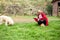 A woman cleans up dog poop on the lawn in the yard of the house. Territory cleaning