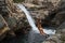 Woman cliff jumper at waterfall