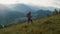 Woman climb hike mountains. Active backpacker walk nature green hill at sunrise.
