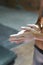 Woman climber is chalking hands with white chalk powder before climb in indoor climbing gym. woman getting ready to