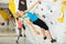 Woman climbing tall, indoor, man-made rock climbing wall