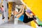 Woman climbing tall, indoor, man-made rock climbing wall