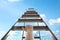 Woman climbing up stepladder against sky with clouds, closeup