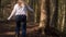 Woman climbs hill in pine forest