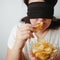 Woman with closed eyes eating unhealthy food