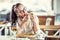 Woman closes her eyes as she bits into a slice of pizza sitting in a restaurant