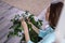 A woman with a cloth of microfiber wipes dust from green leaves, care of plants